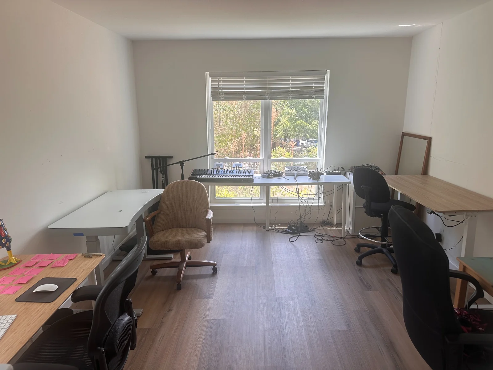 Shared workspace with several desks and office chairs around a sunlit window