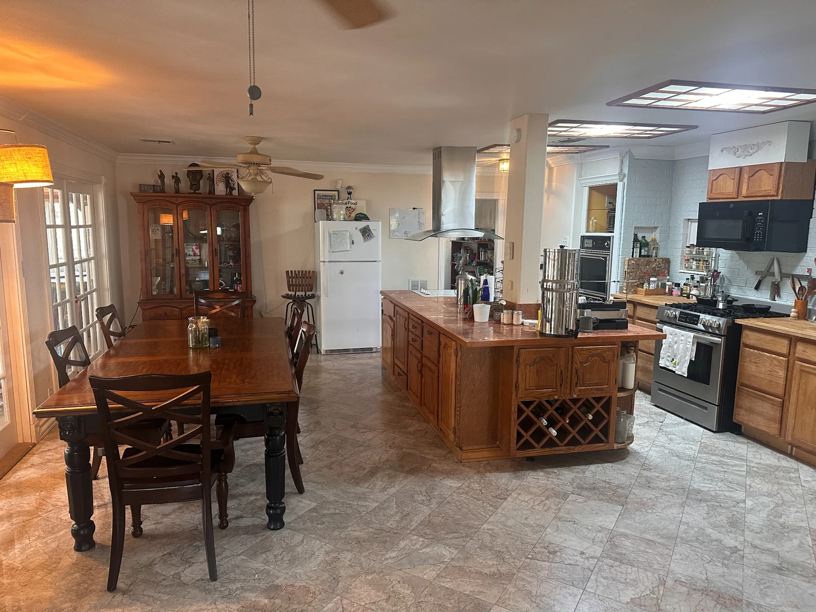 Shared kitchen and dining room with a wooden island, long dining table, and china cabinet